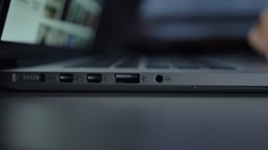Laptop ile çalışma ve beyaz usb tel kablo içine siyah tablo arka plan üzerinde ekleme el yakın çekim doğrudan atış.