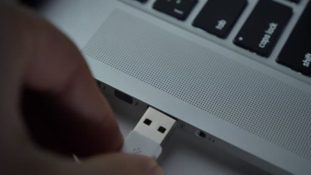 Close-up shot of hand fastly inserting usb cable into laptop on black table background. — Stock Video