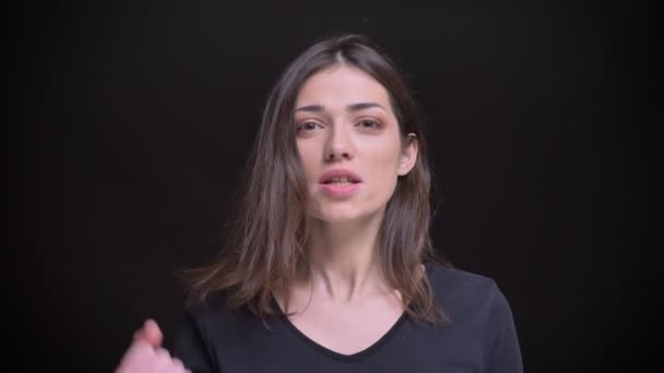 Portrét mladé kavkazské dlouhé vlasy brunetka šťastně směřují úspěchu na černém pozadí. — Stock video