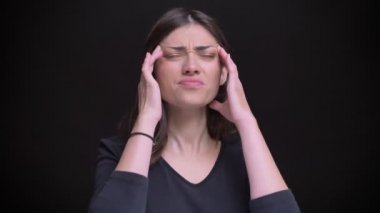 Genç beyaz uzun saçlı esmer kız yapma masaj ve siyah arka plan üzerine baş ağrısı acı portre.