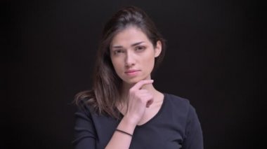 Flirtingly saçlarını dokunmaktan ve siyah arka plan üzerine kamera içine izlerken genç beyaz uzun saçlı esmer kız portresi.