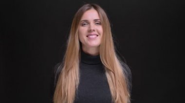 Genç beyaz uzun saçlı sarışın kız kamera siyah arka plan üzerine içine sevinçle gülümseyen portresi