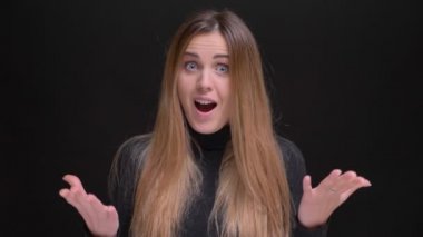 Genç beyaz uzun saçlı sarışın kız eğlence fotoğraf makinesi içine siyah arka plan üzerinde gösterilen portresi.