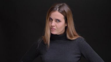 Genç beyaz uzun saçlı sarışın kız kamera siyah arka plan üzerine olumsuz kafasını dönüşüyor portresi.