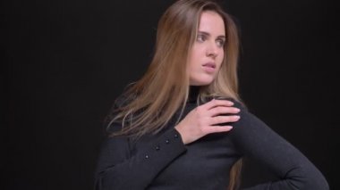 Genç beyaz uzun saçlı sarışın kız zarif şekilde içine kamera siyah arka plan üzerine poz portresi.