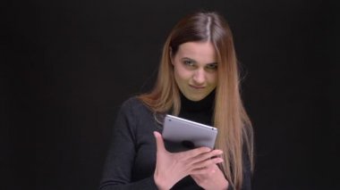 Genç uzun saçlı sarışın kız gülümseyerek içine kamera siyah zemin üzerine yeşil ekran tablet gösterilen portresi.