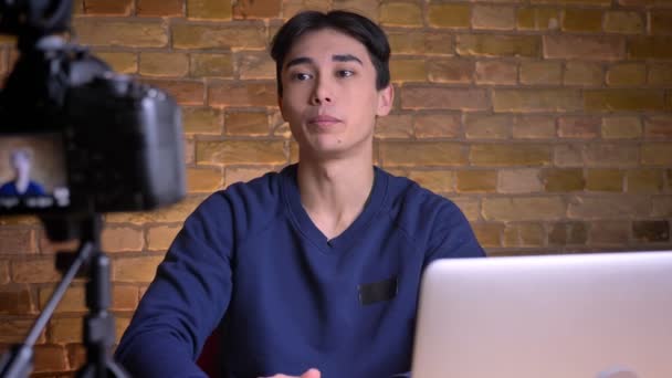 Detailní portrét mladého korejského mužského blogger mluvit na kameru a gestikuloval interiéru — Stock video