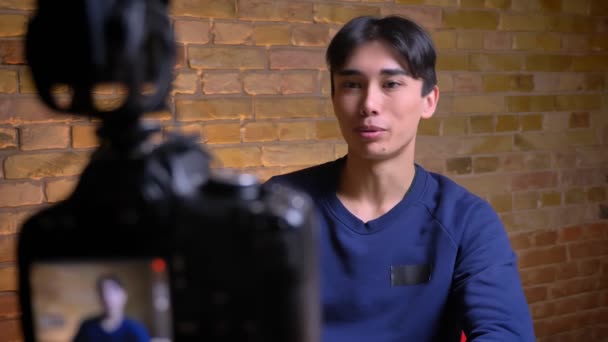 Nahaufnahme Porträt junger koreanischer männlicher Videoblogger gestikuliert und sagt, um den gleichen Po zu treffen und abonnieren — Stockvideo