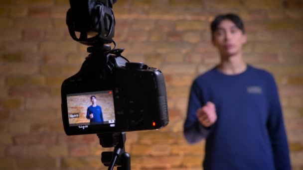 韓国の男性 videoblogger、スピーカーに移すと話を記録カメラのクローズ アップ撮影します。 — ストック動画