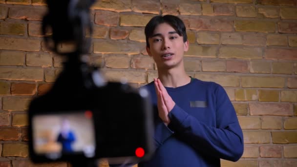 Vértes lő a fiatal koreai férfi videoblogger beszélt, és lét rögzített kamera — Stock videók