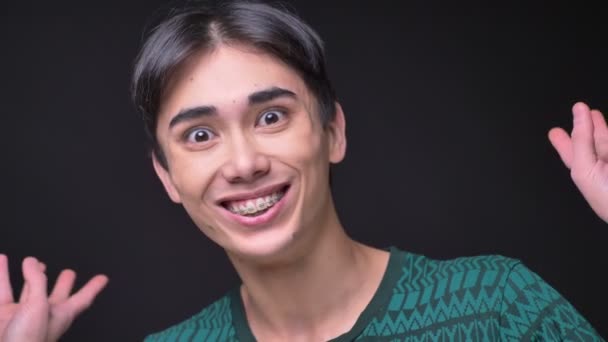 Портрет молодих привабливі Корейська чоловічого отримання здивований і схвильований під час дивлячись на камеру крупним планом — стокове відео