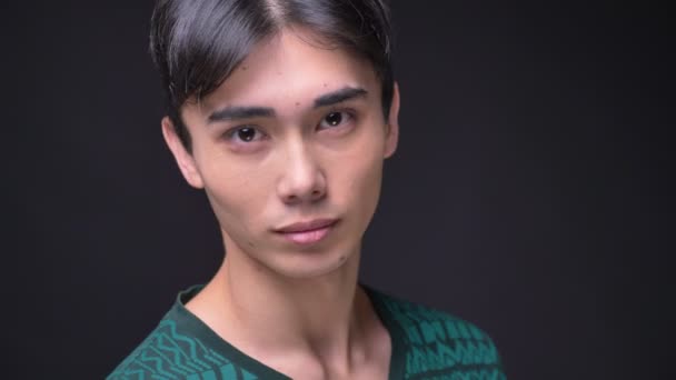 Detailní portrét mladé atraktivní korejské mužské otáčení ze strany při pohledu na fotoaparát a usmívá se — Stock video