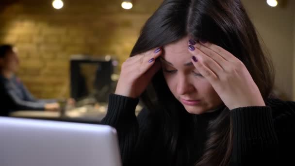 成人黑发高加索女商人在笔记本电脑上工作的特写镜头 头痛累 — 图库视频影像