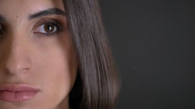 Yakın çekim yarı-portresi beyaz uzun saçlı esmer kız siyah arka plan üzerine mesafe içine sakince izlerken.