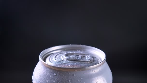Closeup atirar de lata de prata de refrigerante carbonatado girando em torno de movimento com fundo isolado no escuro — Vídeo de Stock
