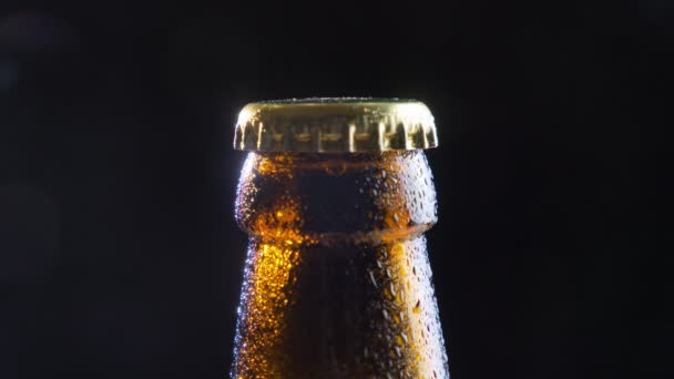 Closeup σουτ του λάμπει μπύρα μπουκάλι εξώφυλλο με το φόντο που απομονώνονται σε μαύρο — Αρχείο Βίντεο
