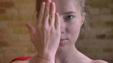 Genç çekici beyaz kadın kamera gülümseyen yarım uygulanan makyaj ile çok güzel bir yüzün gösterilen closeup portresi
