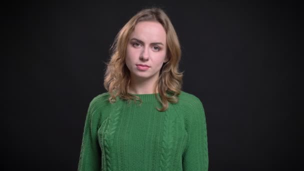 Closeup portrait of adult caucasian female looking straight at camera with emotionless facial expression — Stock Video