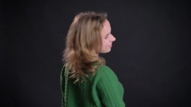Portre portre yetişkin beyaz kadın dönüm arkadan gülümseyerek ve işareti tebrik bir silah sesi gösterilen kameraya bakıyor