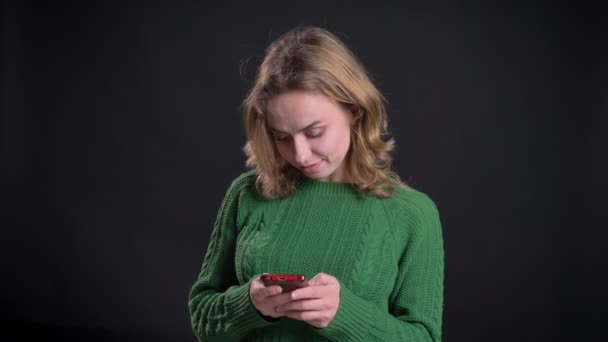 Detailní portrét dospělých Kavkazský žena nenuceně textové zprávy na telefonu před kamerou — Stock video