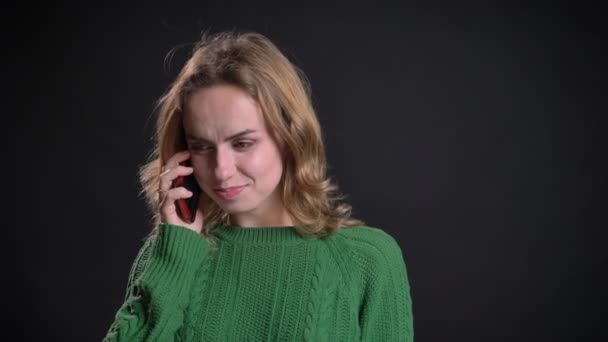 Closeup portrait of adult caucasian female making a phone call and talking while smiling in front of the camera — Stock Video