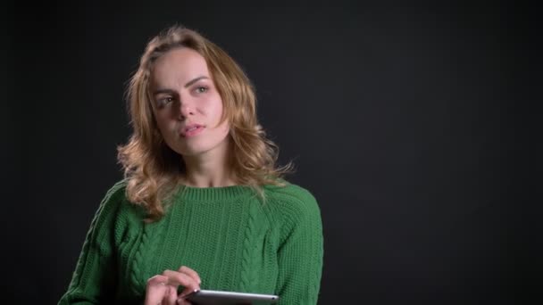 Retrato de primer plano de una mujer caucásica adulta usando una tableta y siendo considerado delante de la cámara — Vídeos de Stock