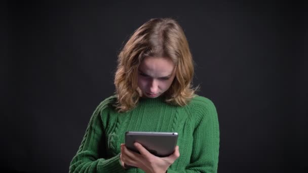 Nahaufnahme Porträt einer erwachsenen kaukasischen Frau mit dem Tablet und zeigt der Kamera lächelnd den blauen Bildschirm — Stockvideo