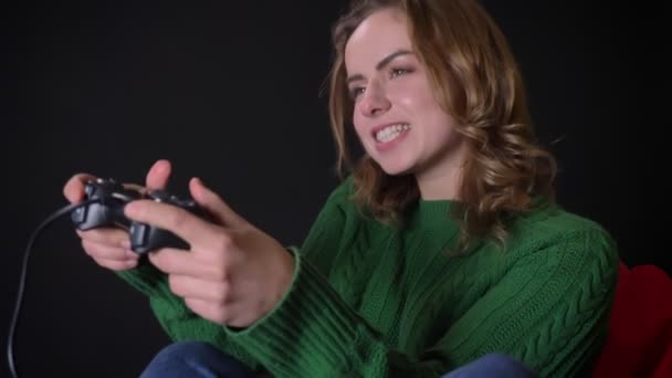 Primer plano retrato o adulto caucásico hembra jugando videojuegos con disfrute en el interior — Vídeos de Stock
