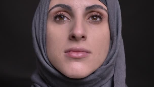 Close-up portret van vrouwelijke handen doet make-up voor de moslimvrouw in hijab kijken omhoog op zwarte achtergrond. — Stockvideo