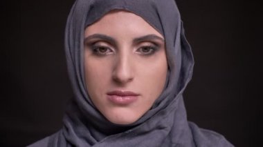 Hijab parlak makyajlı olumlu kamera siyah arka plan üzerine içine izlerken güzel Müslüman kadın portresi