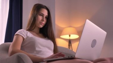Portre portre genç güzel genç kızın rahat ev, Laptop kapalı kaydırma