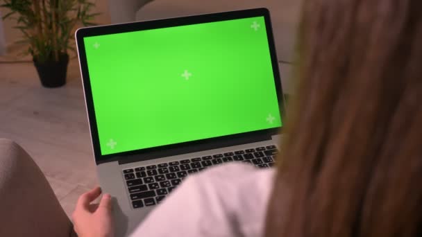 Primer plano de vista trasera de la joven hembra caucásica sosteniendo el ordenador portátil con pantalla verde croma-clave — Vídeos de Stock