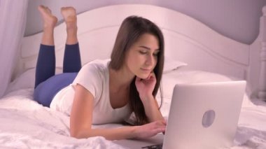 Portre rahat ev de içeride yatan süre gülümseyen dizüstü kullanan genç güzel genç kız portresi