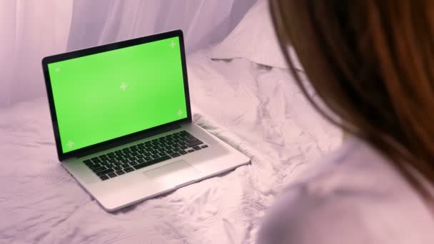 Detailní záběr zadní pohled mladých Kavkazský žena má laptop s fabion chroma-key před ní na posteli doma uvnitř — Stock video