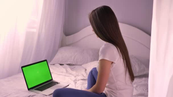 Vértes portré fiatal vonzó kaukázusi nő keresi zöld croma-kulcs képernyő a laptop és kamera mosolyogva fordult — Stock videók