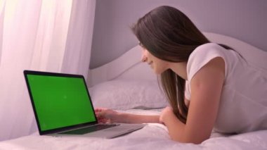 Chroma anahtar yeşil ekran ile Laptop video izlerken ve gülen genç neşeli beyaz kadın portresi portre