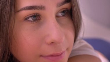 Doğruca kameraya bakarak yeşil gözlü genç beyaz kadın yüzü closeup portresi.