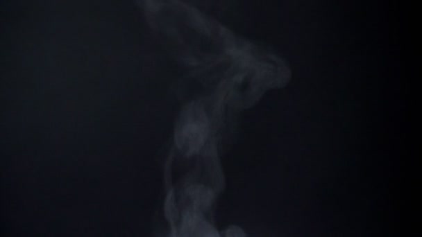 Close-up tiro de vaporizar fumaça voando sobre fundo preto . — Vídeo de Stock