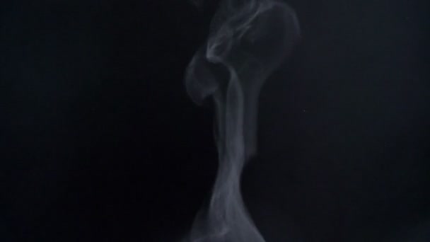 Primo piano colpo di fumo vaporizzante dissolvenza lentamente volare su sfondo nero . — Video Stock