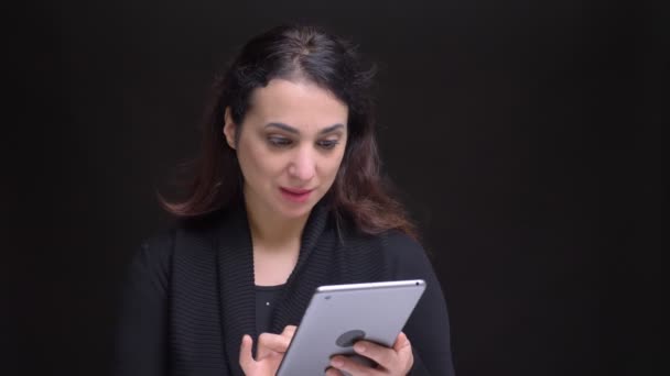 Portre portre genç çekici beyaz kadın kullanarak tablet sonra kameraya bakıyor ve gülümsüyor — Stok video