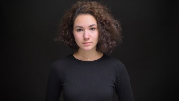 Closeup portrait of young beautiful female getting surprised and excited while looking at camera with background isolated on black — Stock Video