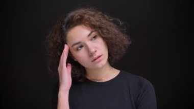 Portre portre genç modern beyaz kadın kıvırcık saçlı rahatsız bir baş ağrısı almak ve rulo bir göz yapma