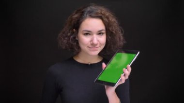 Dizüstü bilgisayarda dokunarak ve kamera için düz yeşil ekran gösterilen genç güzel beyaz kadın portresi portre