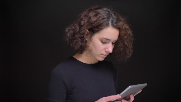Zijaanzicht van de jonge Kaukasische vrouw met behulp van de tablet kijken camera en lacht vrolijk — Stockvideo