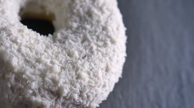 Yavaş yavaş gri tablo arka plan üzerinde iplik yakın çekim yarı-shot beyaz donut ile Hindistan cevizi cips.