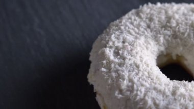 Yavaş yavaş gri tablo arka plan üzerinde iplik yakın çekim yarı-shot lezzetli beyaz donut ile Hindistan cevizi cips.
