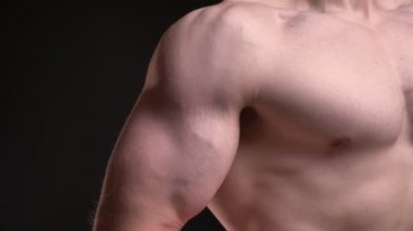 Yakın çekim portre siyah arka plan üzerine erkek kas pazı.