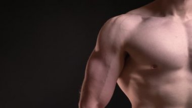 Erkek kas pazı ve göğsü siyah arka plan üzerine yakın çekim portre.