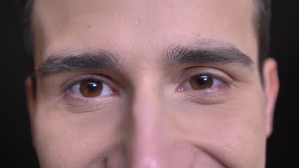 Closeup πυροβολούν από νέους Καυκάσιος ανδρικό πρόσωπο με καστανά μάτια, κοιτάζοντας κατευθείαν σε κάμερα με χαμογελαστό έκφραση του προσώπου — Αρχείο Βίντεο
