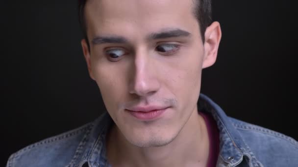 Close-up retrato de jovem caucasiano homem squinting seus olhos fazendo um engraçado facial expressão — Vídeo de Stock